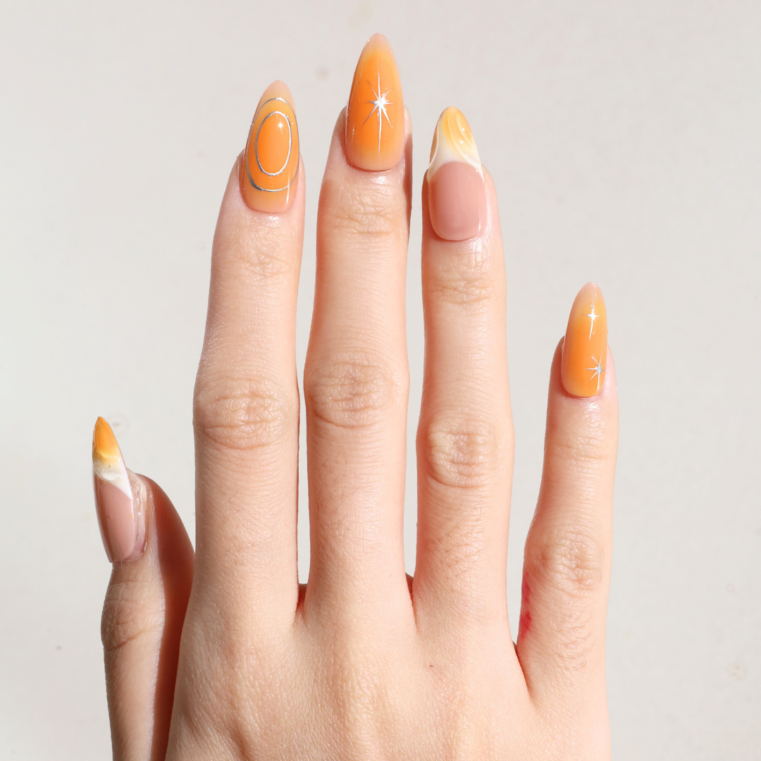 Light skinned hand with Orange Chrome Moderne Nails