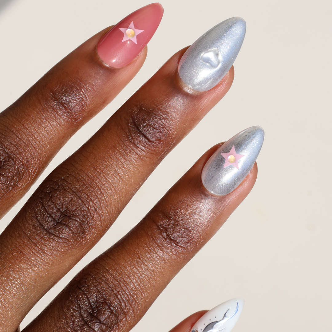 Angled photo of dark skinned hand with Pink and Chrome Gem Nails