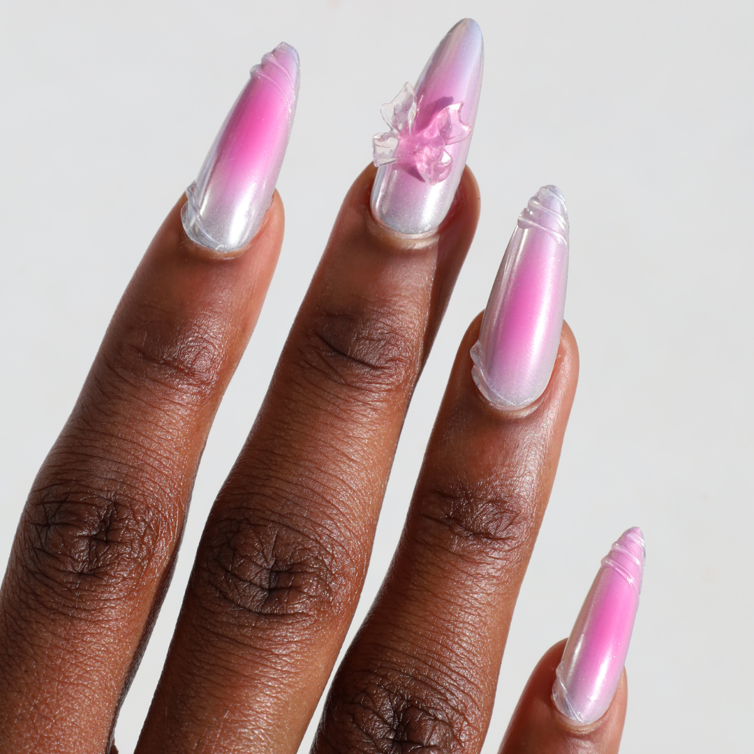 Dark skinned hand with Pink Aura Chrome Bow Nails