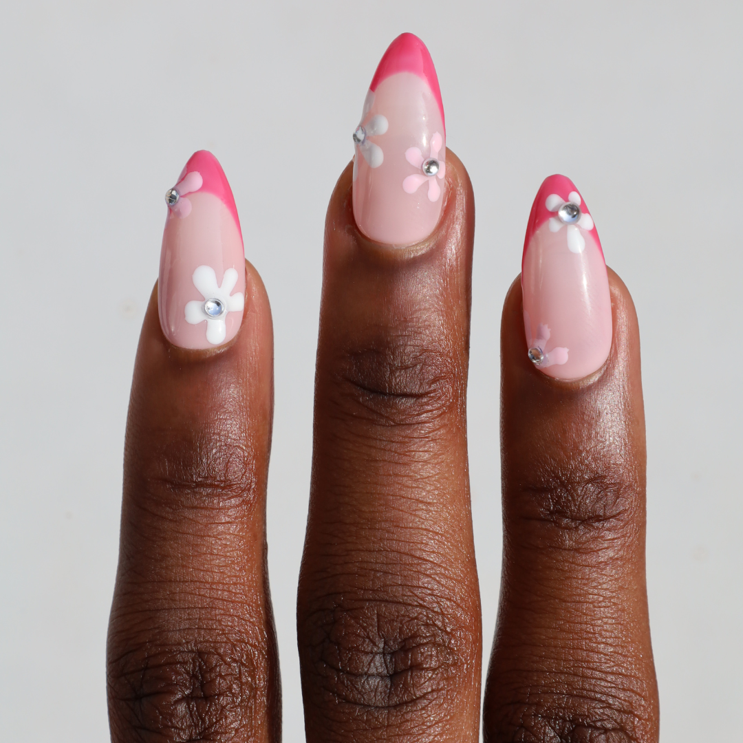 Dark skinned hand with Pink Gem Floral French Tips